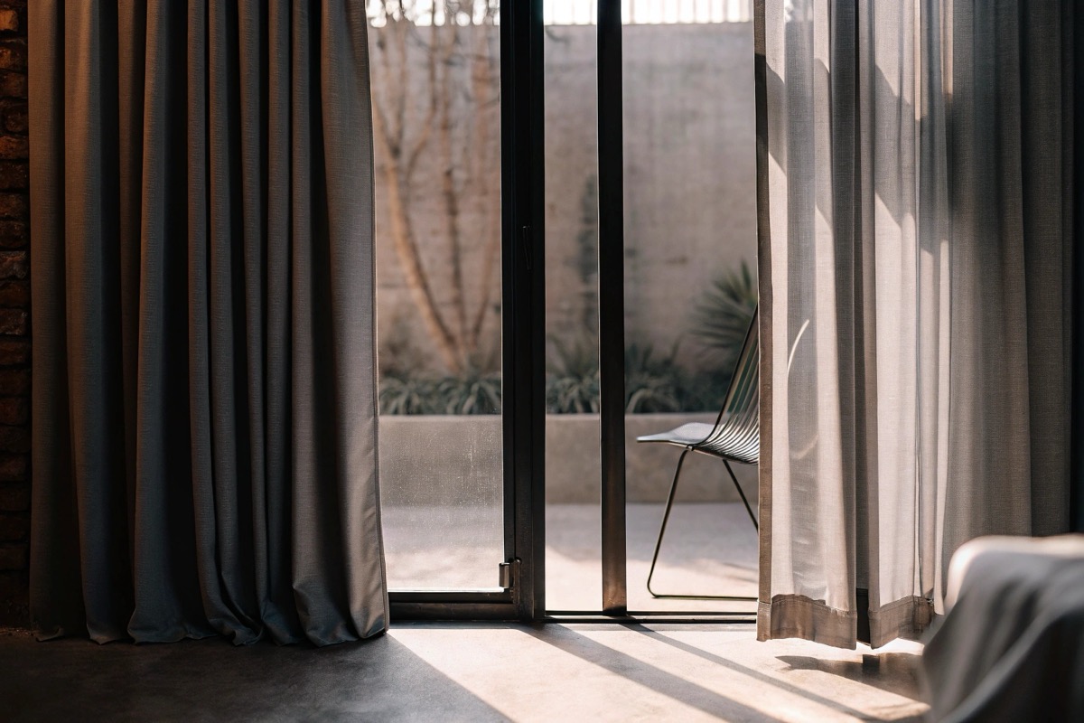 Elegante maßgefertigte Vorhänge in einem modern eingerichteten Wohnzimmer mit natürlichem Lichteinfall